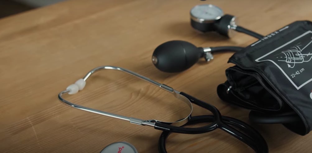 Applying manual blood pressure cuff to upper arm